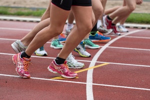 Close up photo of runners’ feet lined up at start of race
