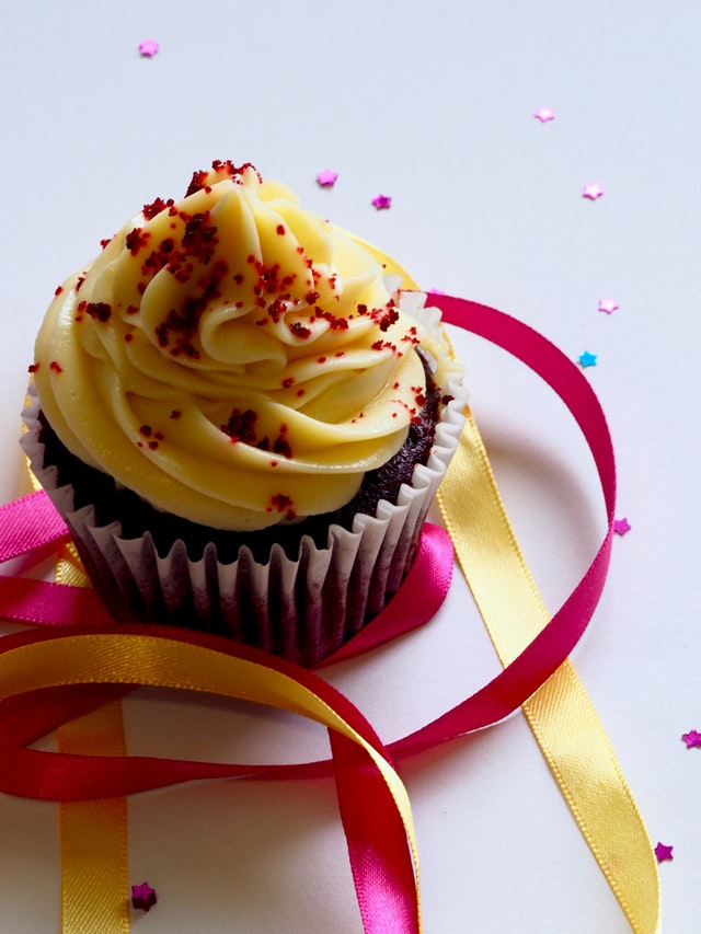 Cute cupcake with colorful ribbons and confetti
